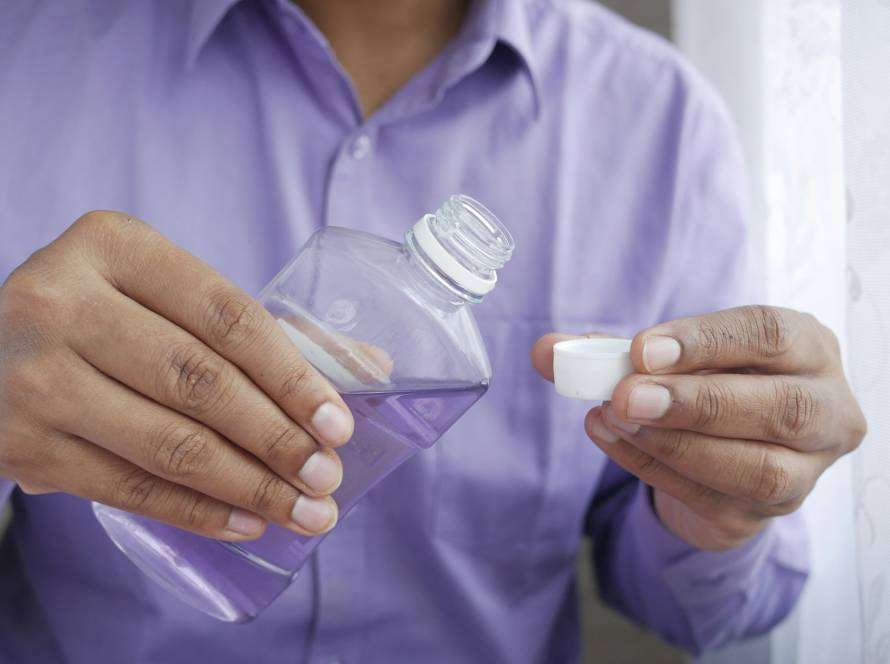 man pouring mouthwash